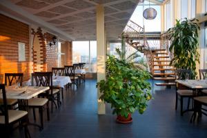 a dining room with tables and chairs and plants at Hotel Asteri in Kyiv