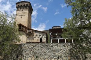 a building with a tower on top of a stone wall at Khergiansha in Mestia +14 photos