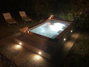 a hot tub with lights in a backyard at night at Sweet Home & Apartments in Fontane Bianche