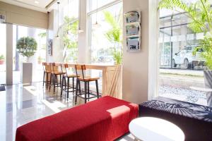 een kamer met een bar met stoelen en een rode bank bij Red Planet Manila Aseana City in Manilla