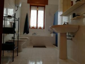 a bathroom with a sink and a tub and a toilet at Frate E Soru in Cannole