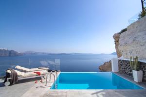 a swimming pool with a view of the water at Santorini Secret Suites & Spa, Small Luxury Hotels of the World in Oia