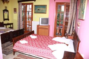 a bedroom with a bed and a television in it at Katerina Hotel in Tolo