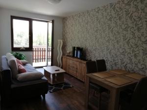 a living room with a couch and a table at Apartmán Skalnička - Tatranská Lomnica in Tatranská Lomnica