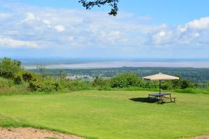 a picnic table with an umbrella on a field at Migombani Camp in Mto wa Mbu