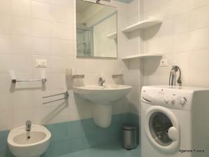 a bathroom with a sink and a washing machine at Residence Mirage in Grado +30 photos