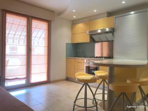 a kitchen with a table and some yellow stools at Residence Mirage in Grado