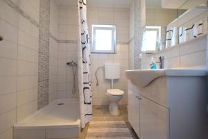 a bathroom with a sink and a toilet and a shower at Apartments Celebrini in Malinska +46 photos