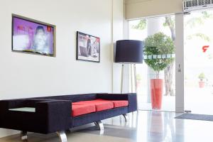 a living room with a black couch with a red seat at Red Planet Manila Aseana City in Manila