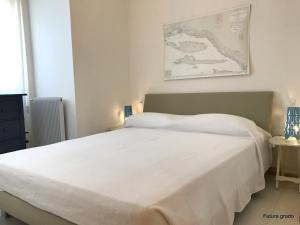 a bedroom with a white bed with a map on the wall at Residence Mirage in Grado