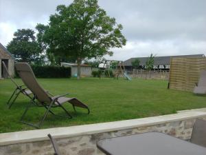 um quintal com uma cadeira e um parque infantil em Gite équestre en Normandie Haras de Sainte Colombe em Sainte-Colombe