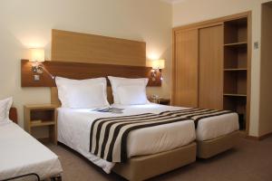 a hotel room with two beds and two lamps at Hotel Principe Lisboa in Lisbon +109 photos