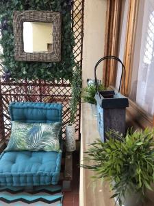 une chaise bleue à côté d'un miroir et de quelques plantes dans l'établissement Casa Anastasia I, à Buendía