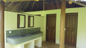 a bathroom with two sinks and two wooden doors at Migombani Camp in Mto wa Mbu