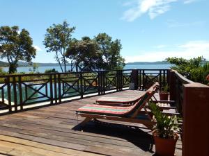 a wooden deck with a bench on top of the water at Zara Village in Nosy Be