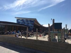 eine Gruppe von Menschen, die auf einem Spielplatz an Tischen sitzen in der Unterkunft Chalet Duinzicht G68 Ameland in Buren