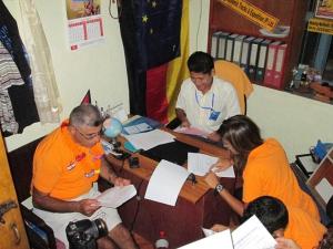 a group of people sitting at a table signing papers at Everest Home Stay Apartment in Pātan