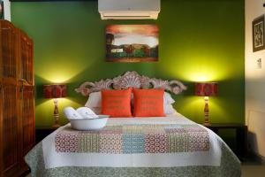 a green bedroom with a bed with red pillows at The Farmers Cottage Bethulie in Bethulie