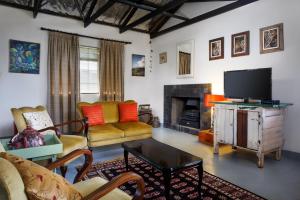 a living room with a television and a fireplace at The Farmers Cottage Bethulie in Bethulie