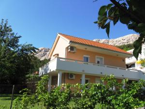 a house with mountains in the background at Apartmani Marija in Baška