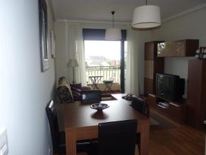 a living room with a wooden table and a dining room at Precioso Apartamento con Spa en Galicia / Playa Catedrales in Foz