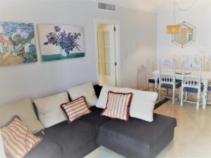 - un salon avec un canapé gris et des oreillers dans l'établissement Banana Beach 1a Li­nea de playa, à Marbella