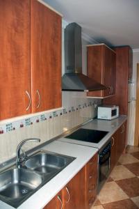 a kitchen with wooden cabinets and a sink and a stove at Casa Rural Maria Belen in Ruidera