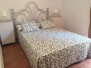 a bed with a black and white comforter and pillows at Vivienda Rural in Olivares