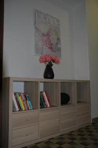 una estantería de madera con un jarrón con flores. en Il Ciliegio Apartment, en Monti