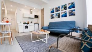 a living room with a blue couch and a table at Santiago Center Rooms in Santiago de Compostela