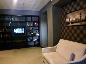 a living room with a white chair and a television at Westend Hotel Kyiv in Kyiv