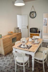 een keuken met een tafel met stoelen en een klok aan de muur bij Sofia Pretty Appartament in Palermo