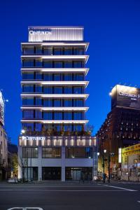 a large building with a clock on the front of it at Centurion Hotel Ueno in Tokyo