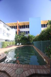 a swimming pool in front of a building at Mid City Luxury Suites in Cairns