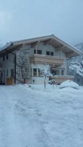 un edificio con mucha nieve delante en Haus-Claudia, en Viehhofen