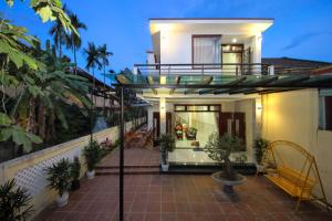 een huis met een balkon en een patio bij Hoi An Dat Cam Homestay in Hội An