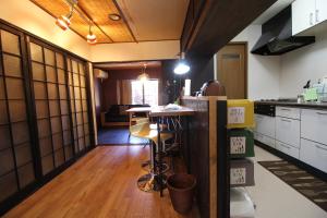 a kitchen with a counter and a table in it at LiB PLUS Kyoto Maiko Han-inn in Kyoto