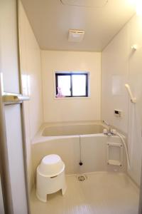 a small bathroom with a tub and a toilet at LiB PLUS Kyoto Maiko Han-inn in Kyoto +34 photos