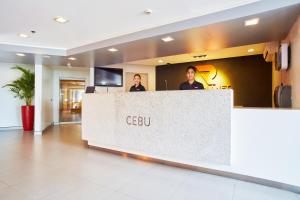 two men standing behind a reception counter in a lobby at Red Planet Cebu in Cebu City