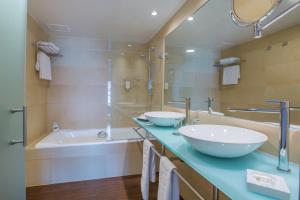 a bathroom with two sinks and a tub at HM Jaime III in Palma de Mallorca
