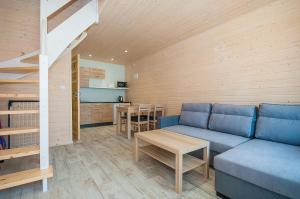 a living room with a blue couch and a table at Sloneczne Sarbinowo in Sarbinowo