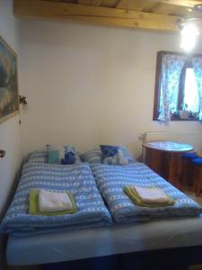 Bett in einem Zimmer mit blauer Bettwäsche und Kissen in der Unterkunft Rekreačná chata pod Jedľovinou in Varín