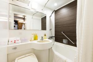 a bathroom with a sink and a toilet and a mirror at Takamatsu Tokyu REI Hotel in Takamatsu