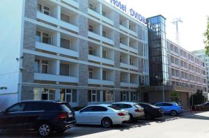 un estacionamiento con autos estacionados frente a un edificio en Hotel Ovidiu en Mamaia