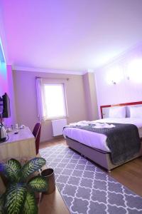 - une chambre avec un lit et une plante dans l'établissement Casablanca Garden Hotel, à Nevşehir