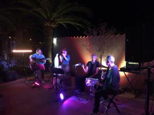 a group of people playing instruments on a stage at night at Camping Arutoli in Porto-Vecchio