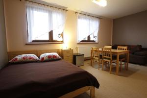 a bedroom with a bed and a table and chairs at Willa Górski Widok in Polanica-Zdrój