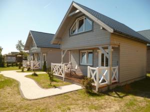 a small house with a porch and a driveway at Cztery Pory Roku in Trzęsacz