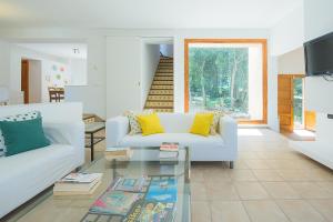 ein Wohnzimmer mit einem weißen Sofa und einem Glastisch in der Unterkunft Mirador - idyllic countryside villa near Arta in Artá