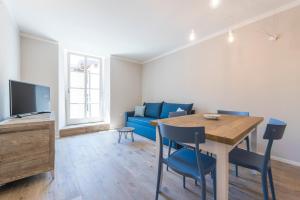 salon ze stołem i niebieską kanapą w obiekcie Casa Tonetta Luxury Apartments w Arco
